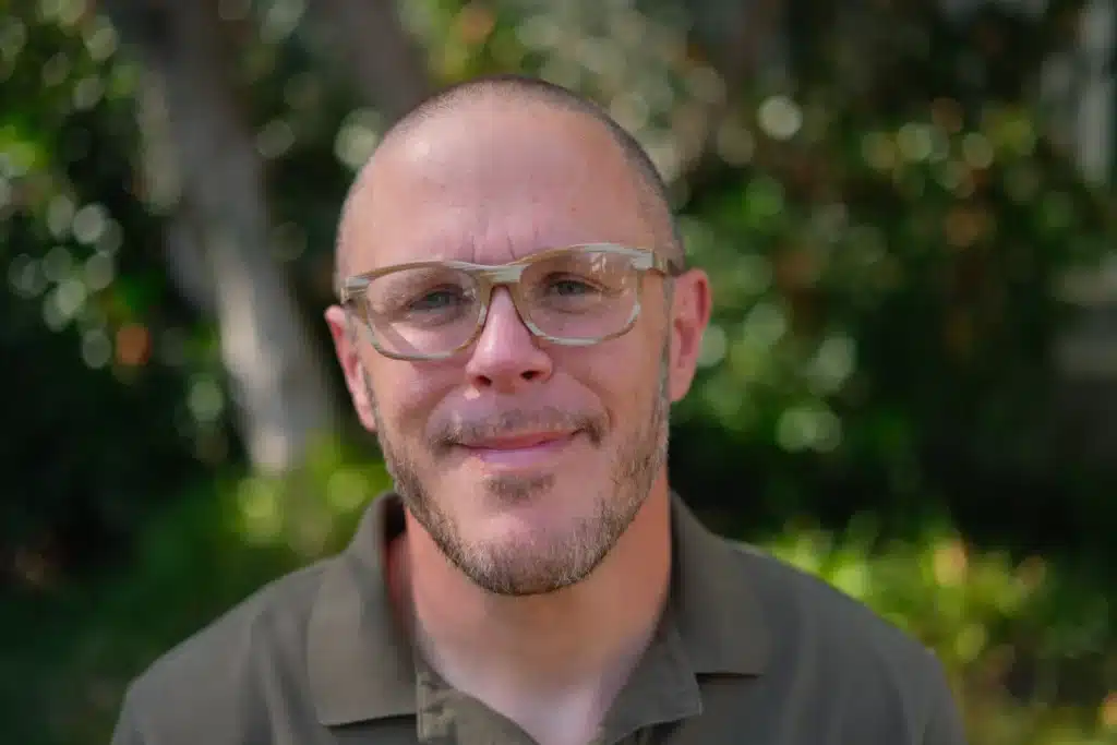 a man wearing glasses and a green shirt