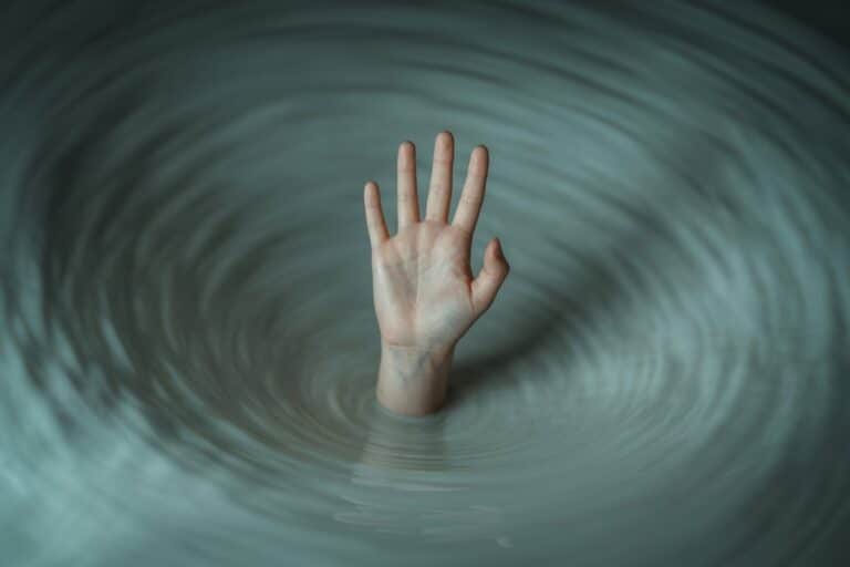 hand reaching out of water or storm, representing addiction