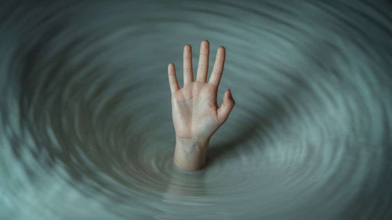 hand reaching out of water or storm, representing addiction